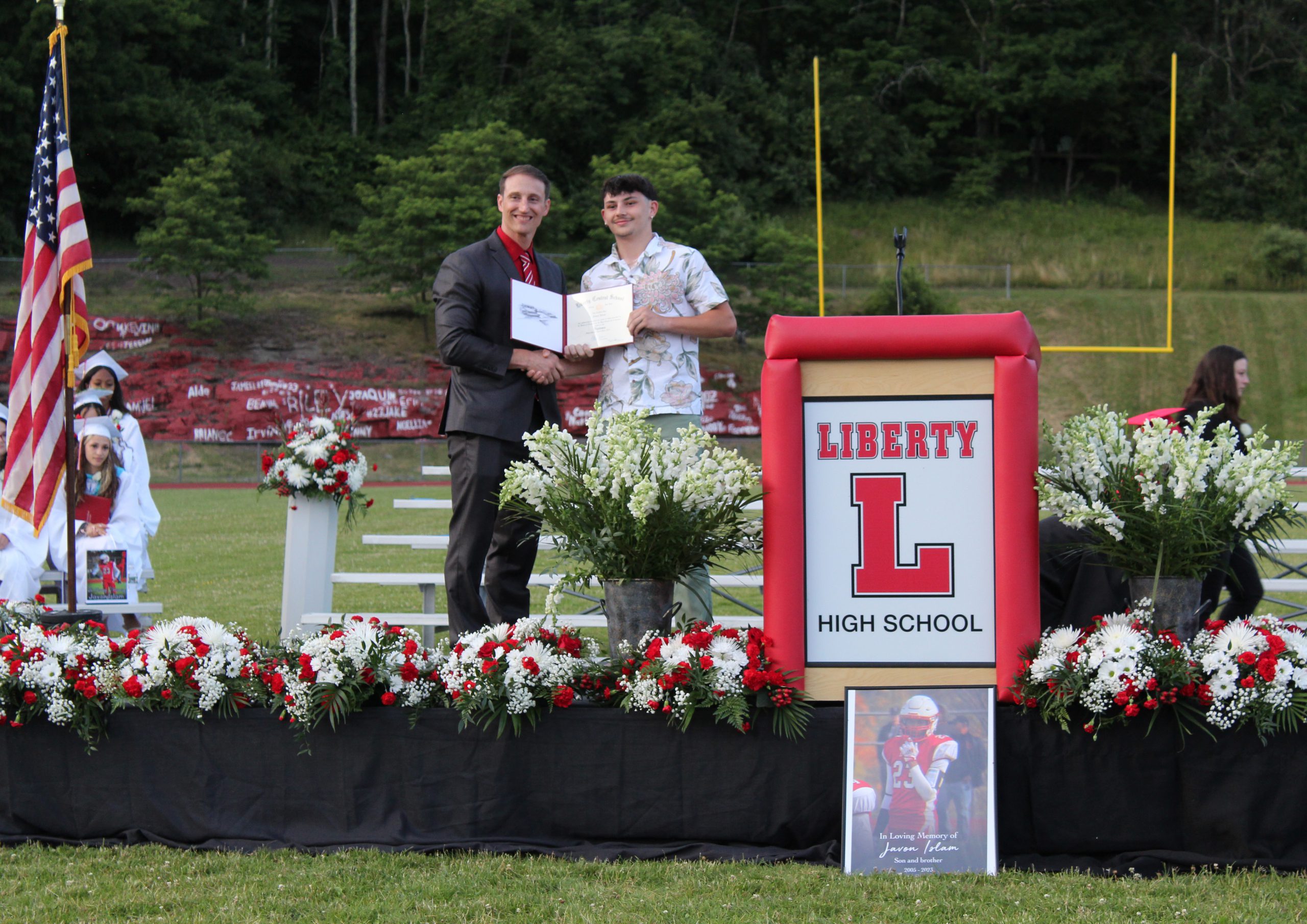 IMG_7681 Two people display a diploma on stage