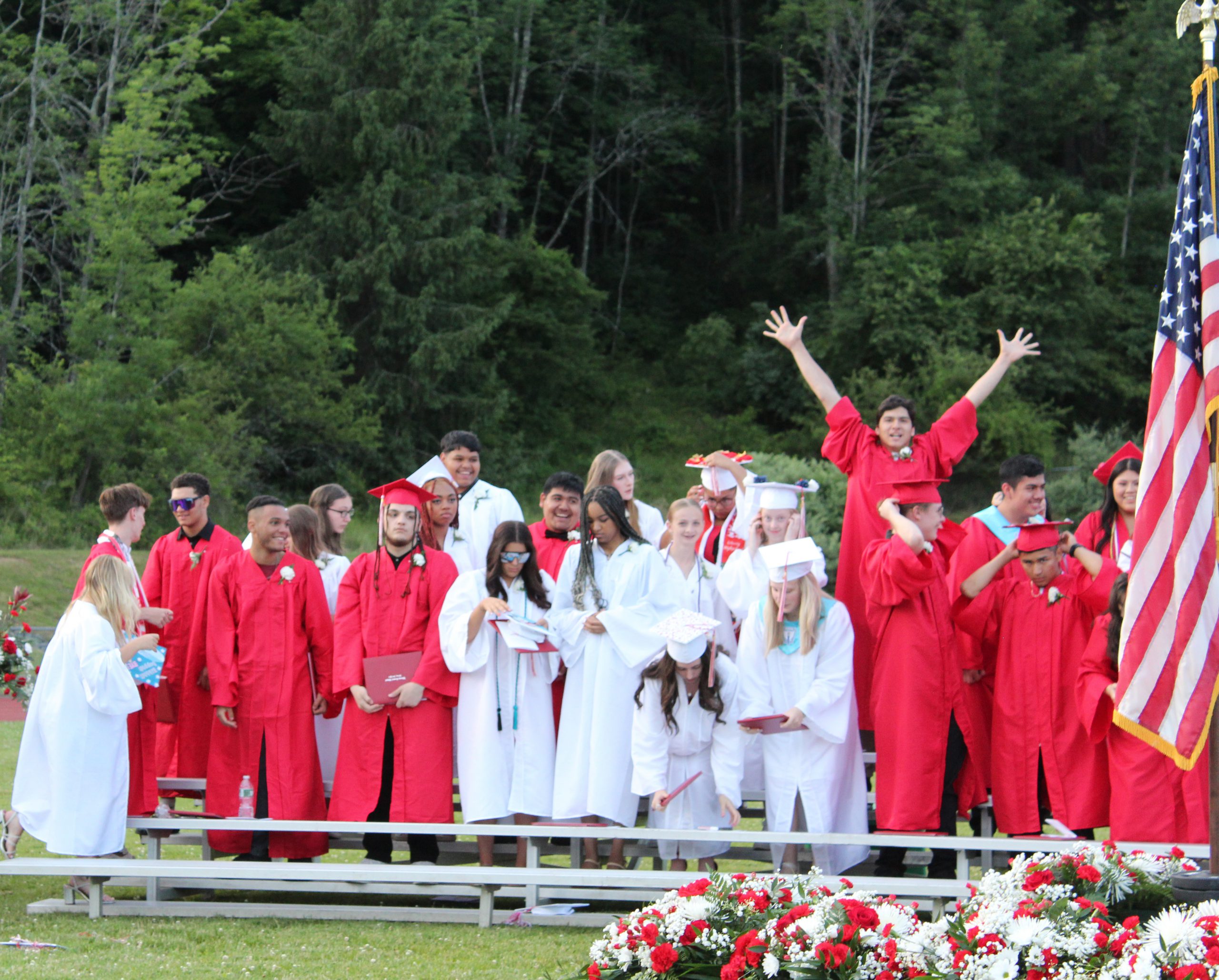 IMG_7689 A student raises his hands in the air as other graduates stand
