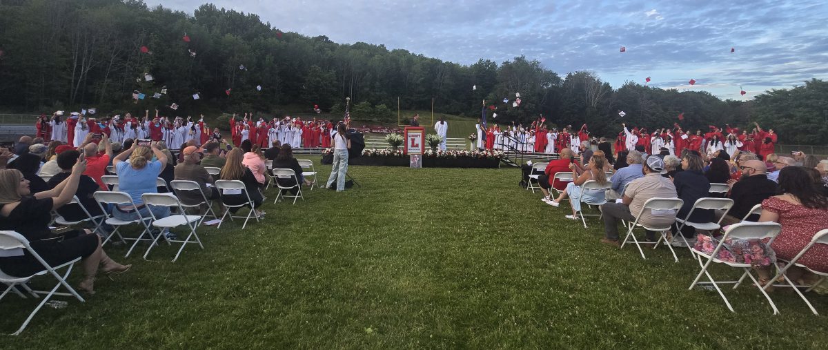 Students toss their caps at the end of the graduation ceremony.