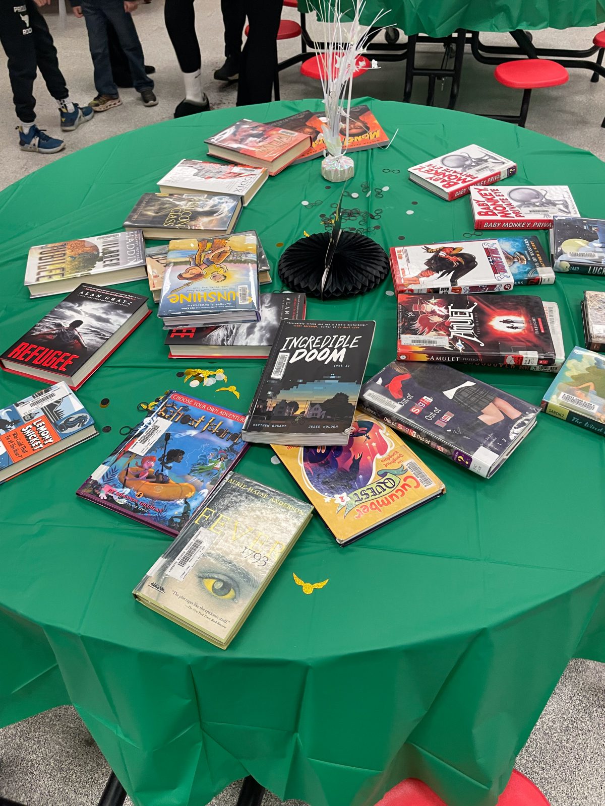 Books sit on a table covered in a green tablecloth