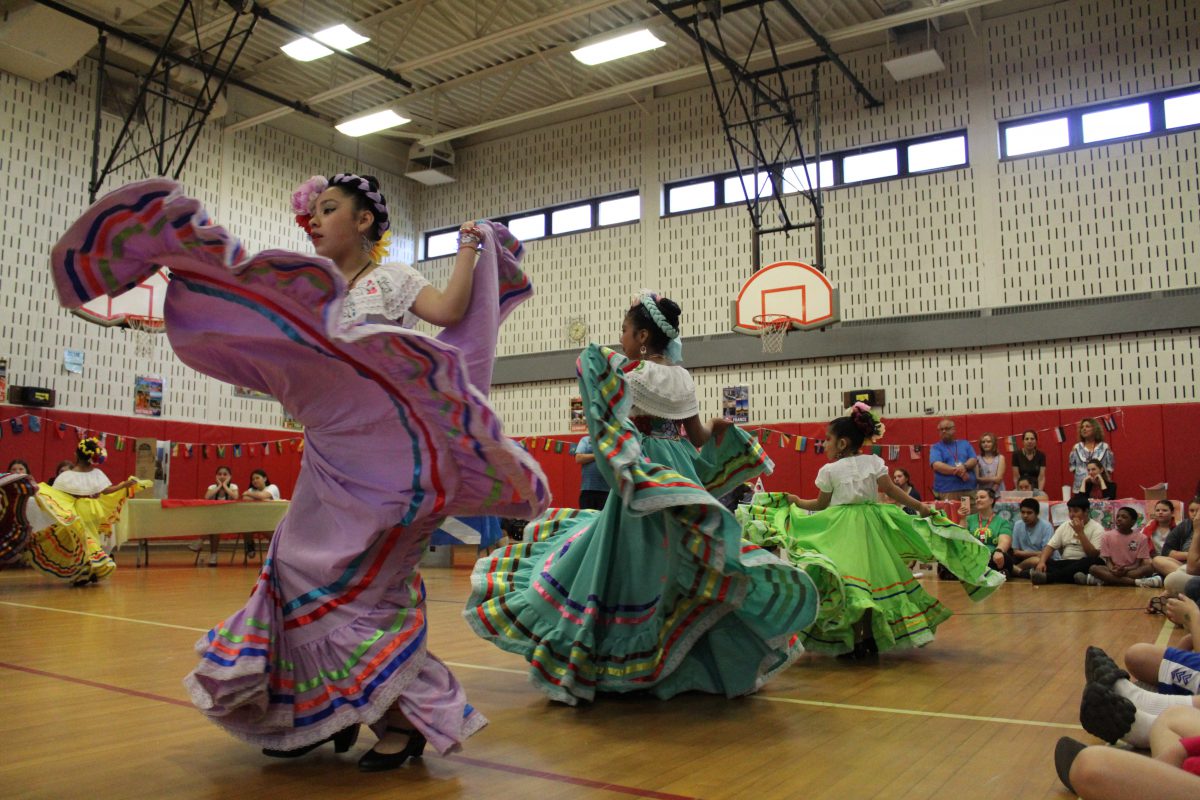 Students perform traditional Mexican dances in a gymnasium