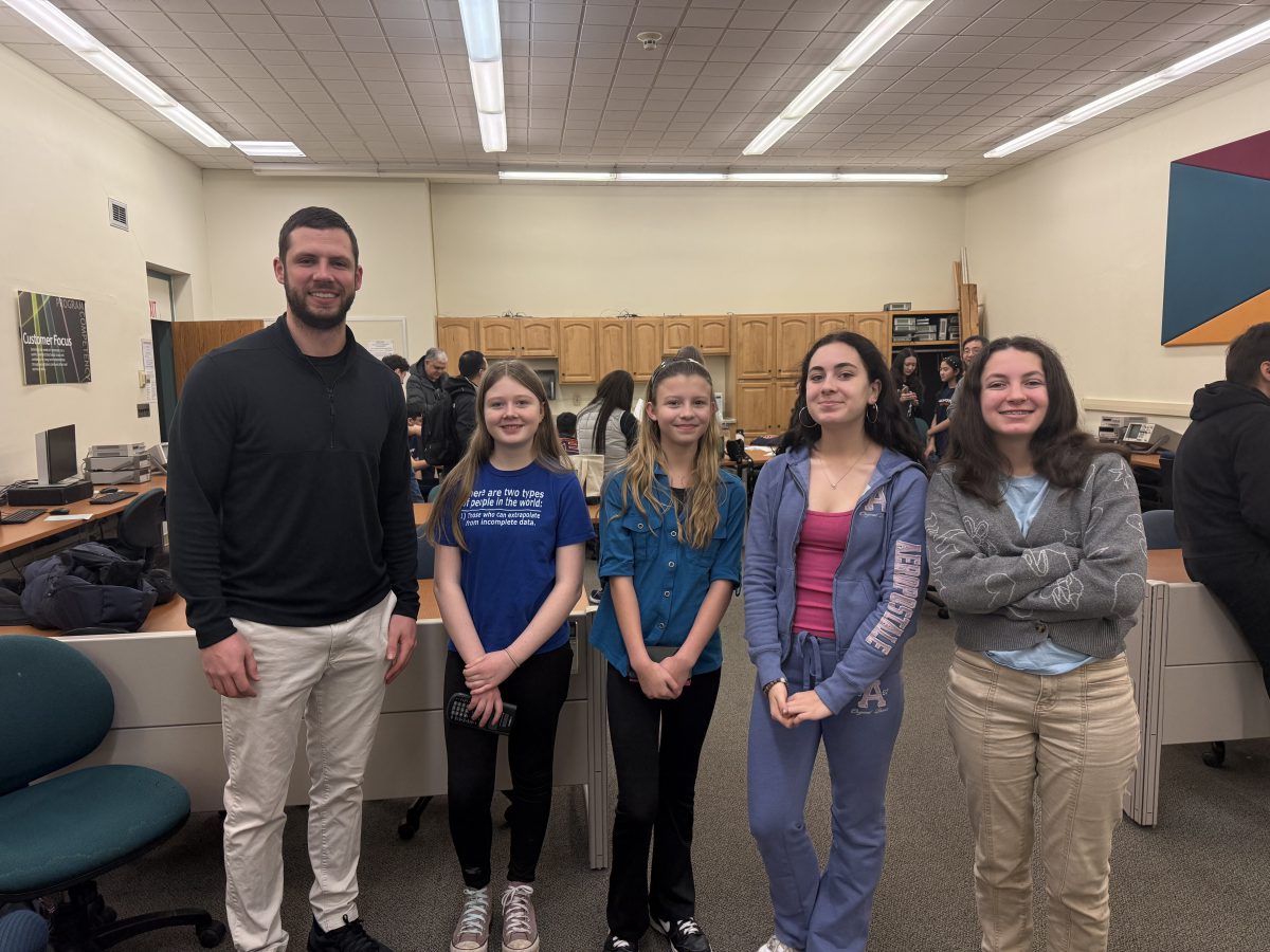 A teacher and four students pose for a photo