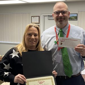 Two people pose for a photo holding certificates