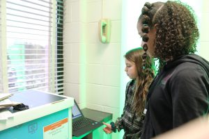 Two students watch a video on a Chromebook