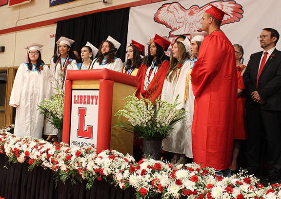 graduation20 Students sing round a podium
