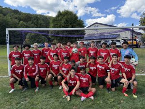 Soccer players pose for a photo in front of a goal