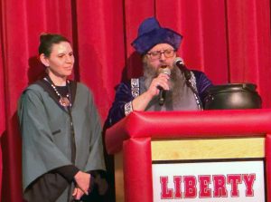 Two people dressed as Harry Potter characters stand at a podium