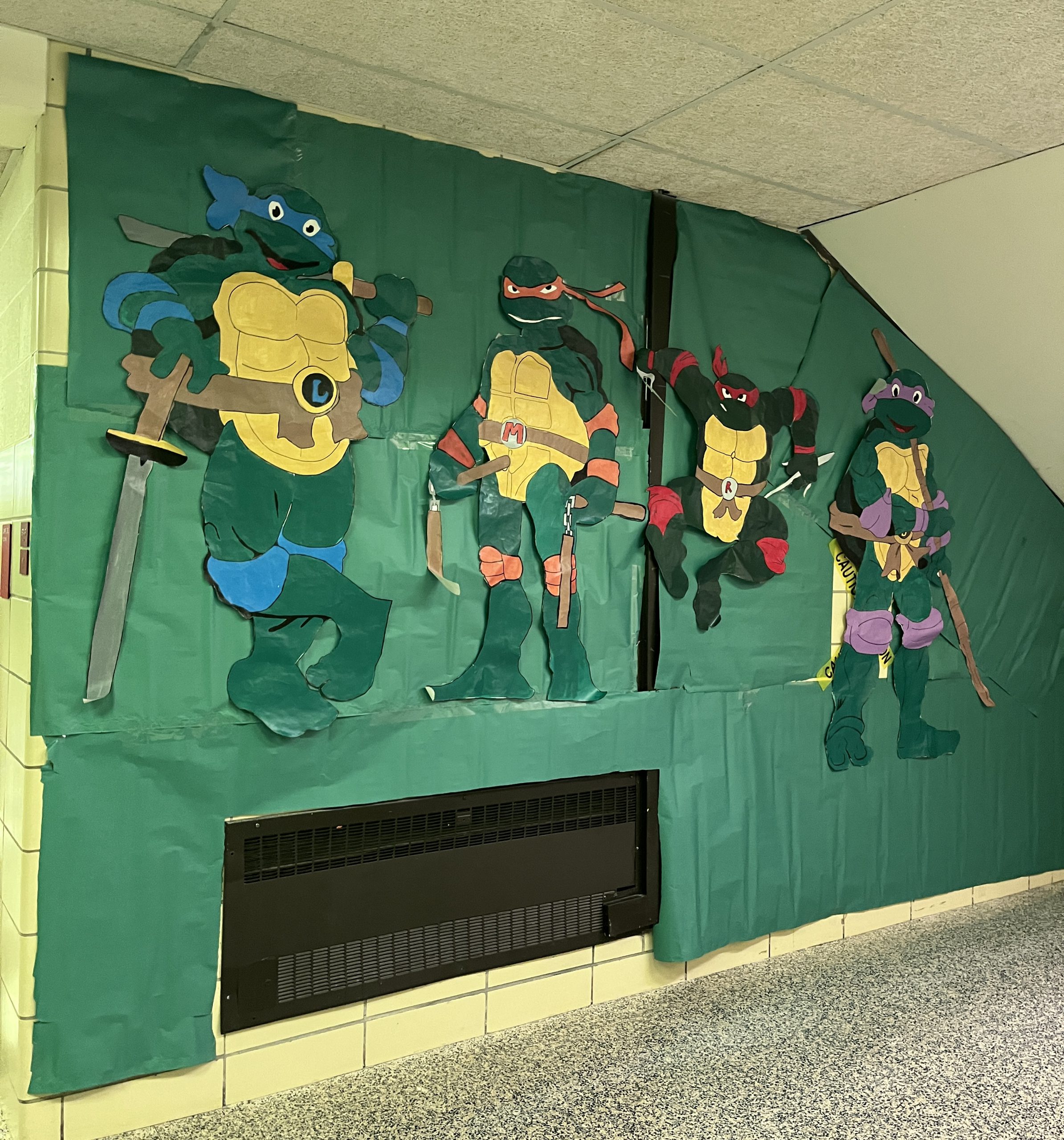 Characters from the Teenage Mutant Ninja Turtles are displayed on a wall