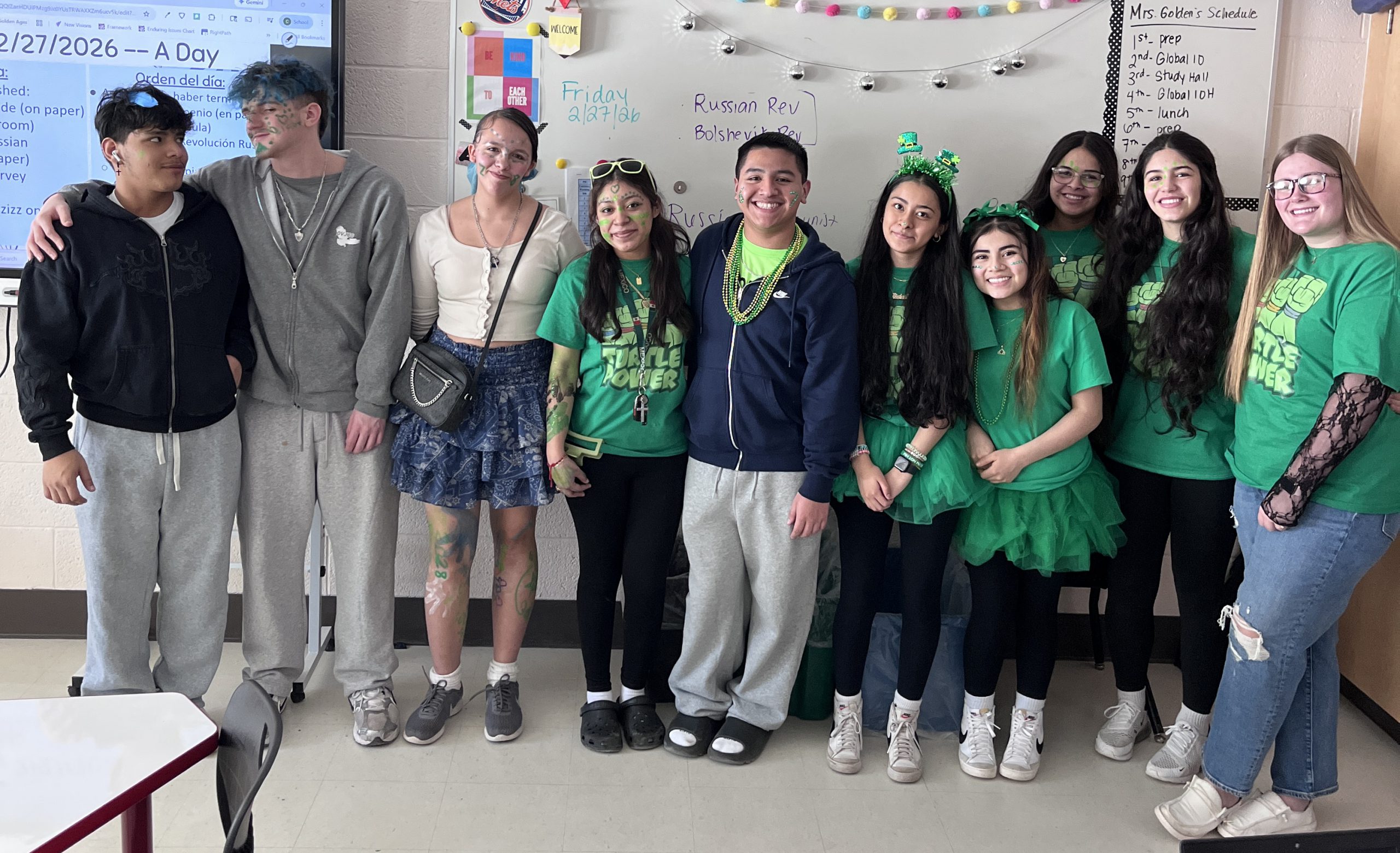 Students dressed in green, some with Class of 2028 shirts, pose for a photo