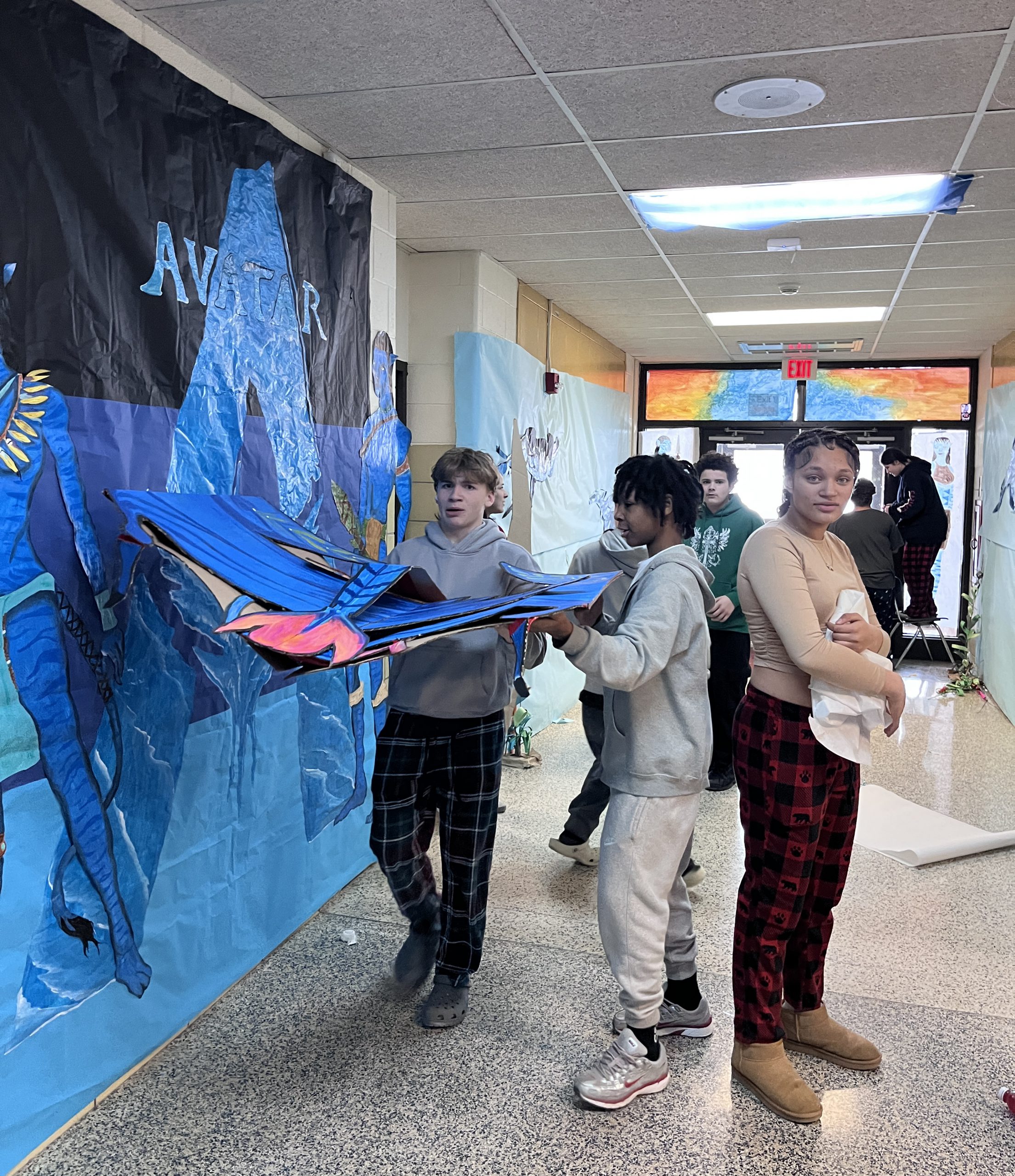 Students decorate a hallway in a blue Avatar theme.