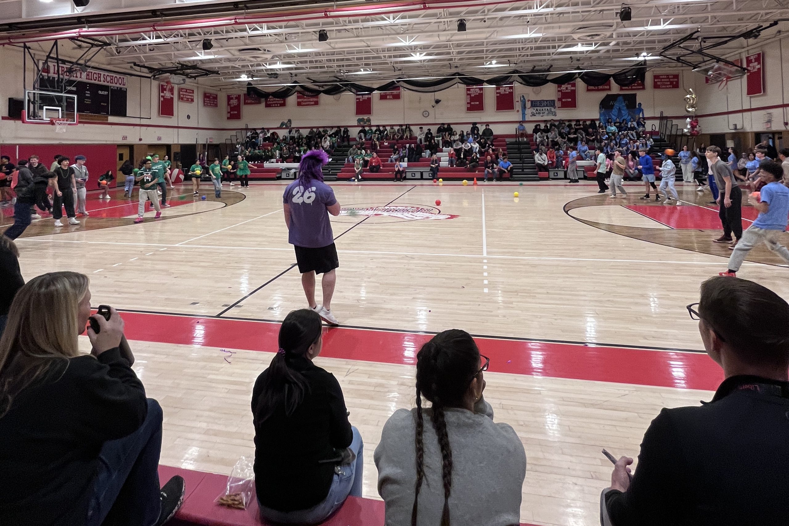 Students in green t-shirts prepare to face off in students in green T-shirts in dodge ball