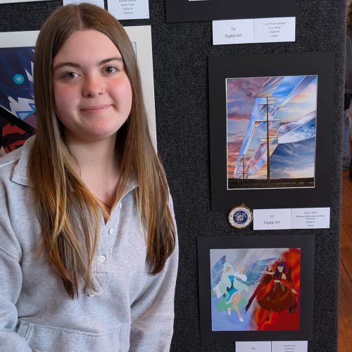 A student poses next to her digital art