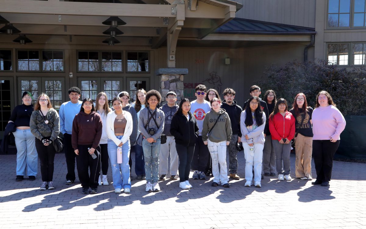 Students pose in front of a building